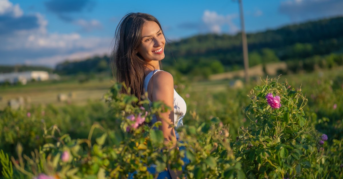 Moteris žydinčiame rožių lauke Bulgarijos Rožių slėnyje