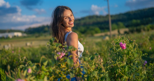 Moteris žydinčiame rožių lauke Bulgarijos Rožių slėnyje